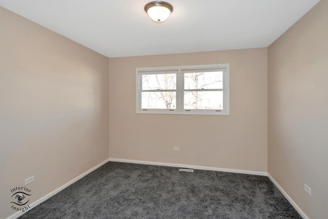 spare room featuring dark carpet