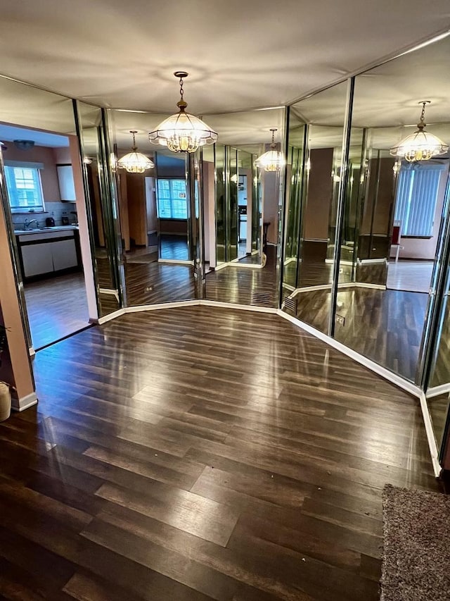 interior space with dark wood-style flooring and an inviting chandelier