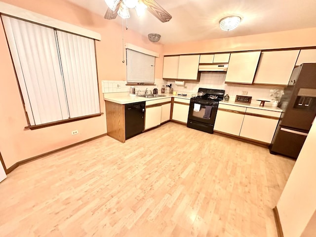 kitchen featuring decorative backsplash, light countertops, under cabinet range hood, and black appliances