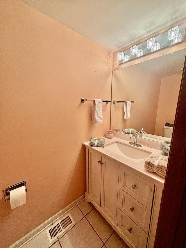 bathroom with baseboards, vanity, visible vents, and tile patterned floors