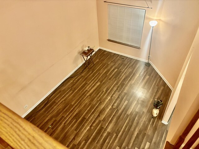 unfurnished room with dark wood-style floors and baseboards