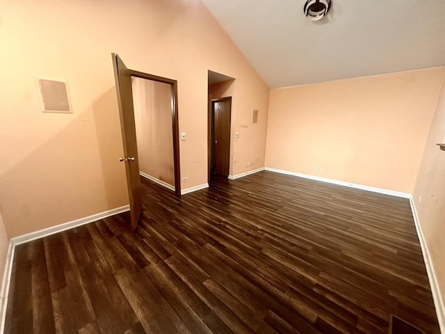 unfurnished bedroom featuring dark wood-style flooring, vaulted ceiling, and baseboards