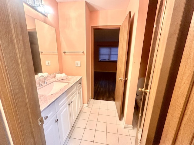 bathroom with vanity, baseboards, and tile patterned floors