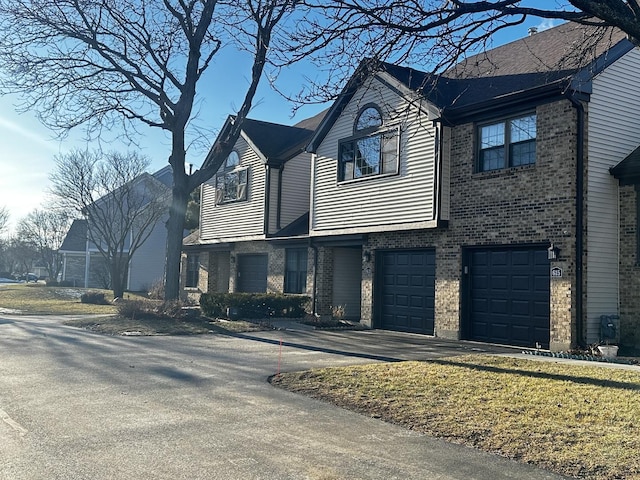 view of front of house with a garage, driveway, and brick siding