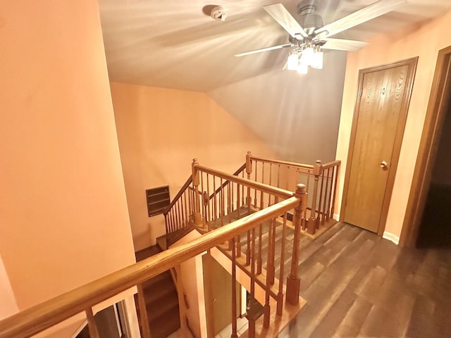 interior space with a ceiling fan, visible vents, vaulted ceiling, and wood finished floors