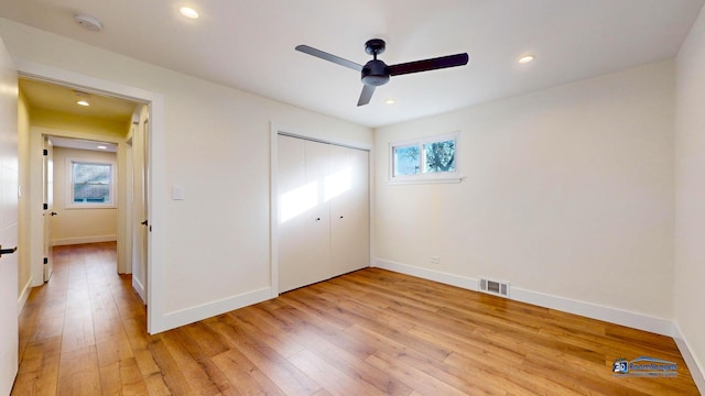 unfurnished bedroom with multiple windows, ceiling fan, a closet, and light hardwood / wood-style flooring