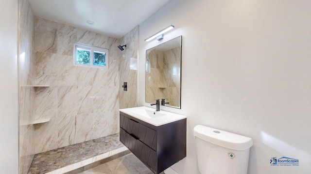 bathroom featuring vanity, toilet, and a tile shower