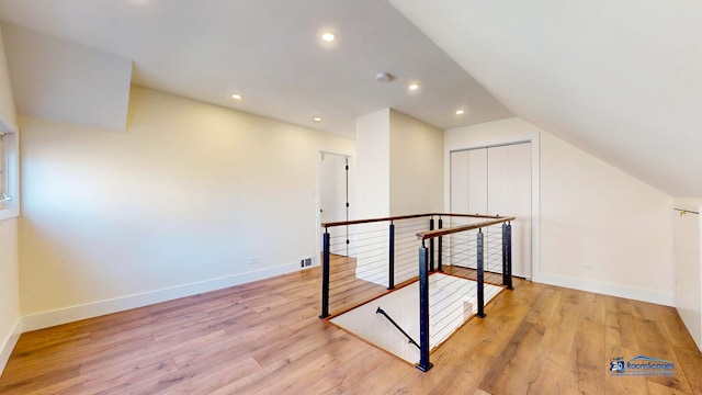 additional living space featuring lofted ceiling and light hardwood / wood-style floors