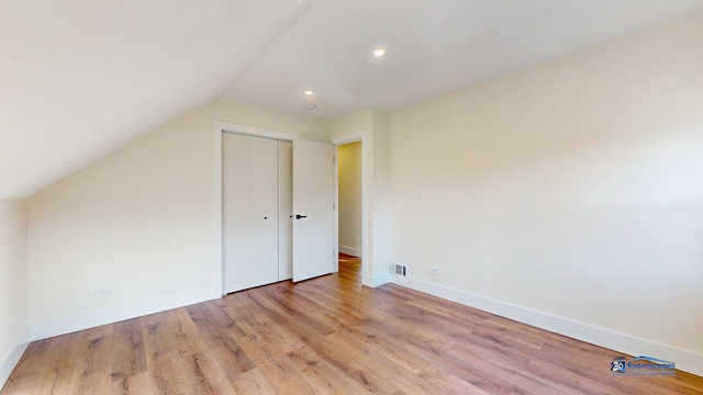 bonus room with lofted ceiling and light hardwood / wood-style floors