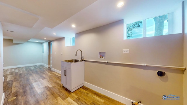 laundry room featuring hookup for a washing machine, sink, and light wood-type flooring