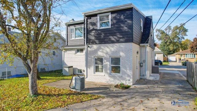 back of property with central AC unit and a patio