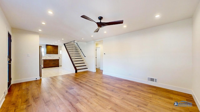 unfurnished living room featuring ceiling fan and light wood-type flooring