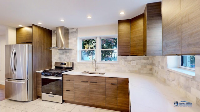 kitchen with wall chimney exhaust hood, stainless steel appliances, sink, and tasteful backsplash