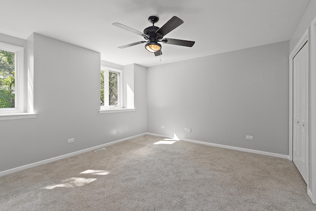 spare room featuring ceiling fan and light carpet