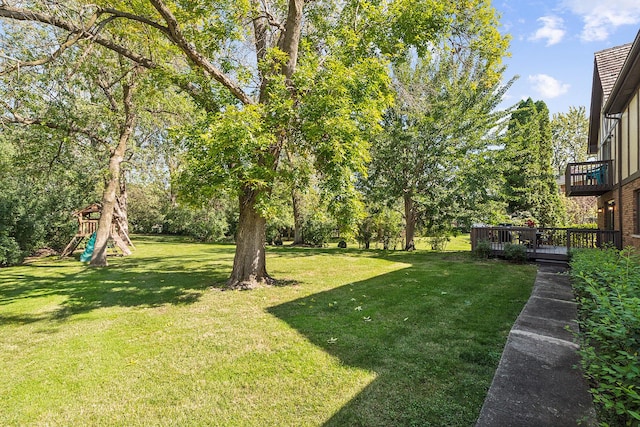 view of yard with a wooden deck and a playground