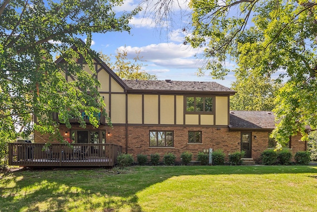 rear view of property featuring a deck and a lawn