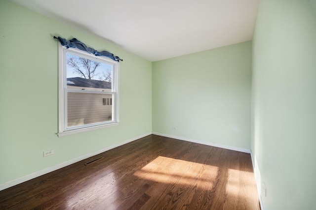 unfurnished room with dark wood-type flooring