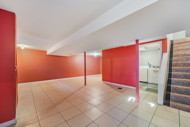 basement with separate washer and dryer and light tile patterned floors