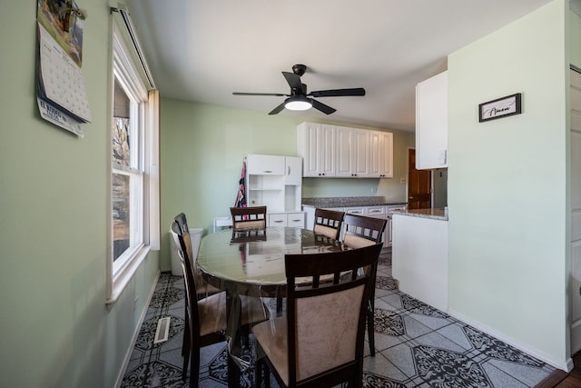 dining space with tile patterned floors and ceiling fan