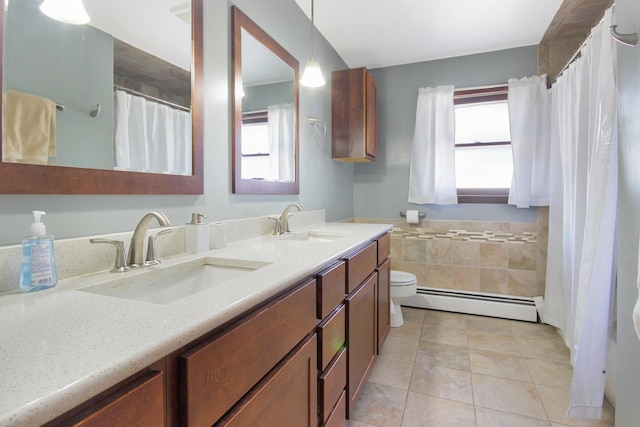 bathroom featuring a baseboard radiator, tile patterned floors, vanity, and a wealth of natural light