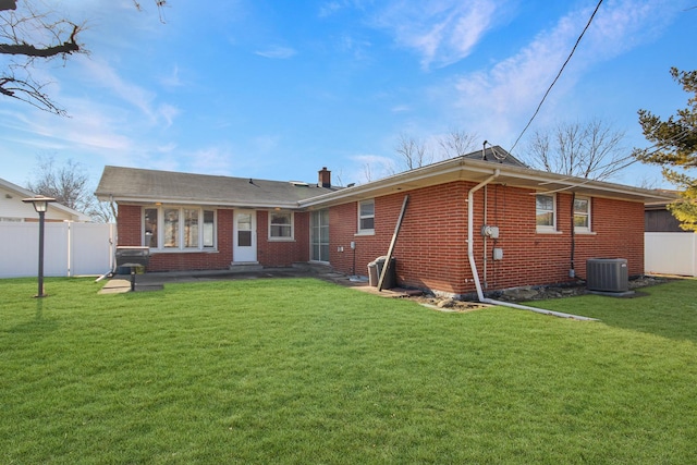 back of property featuring central AC unit and a lawn