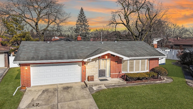 single story home with a garage and a lawn