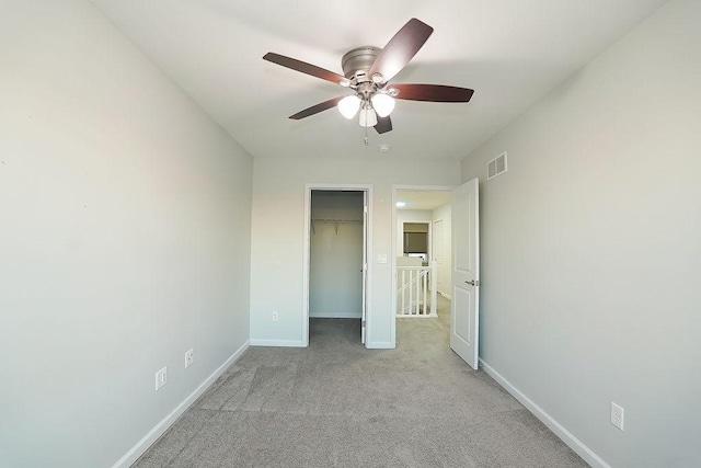 spare room featuring light colored carpet and ceiling fan