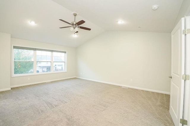 spare room with lofted ceiling, light carpet, and ceiling fan