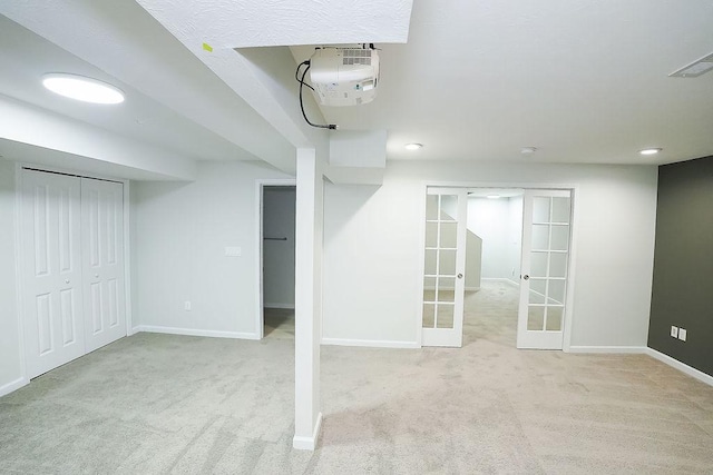 basement featuring french doors and light carpet