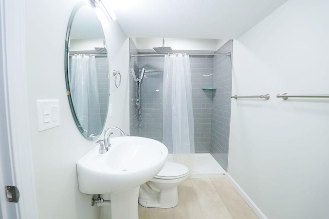 bathroom featuring hardwood / wood-style flooring, toilet, and a shower with shower curtain