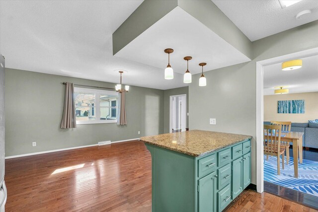 kitchen with green cabinetry, dark hardwood / wood-style flooring, kitchen peninsula, and decorative light fixtures