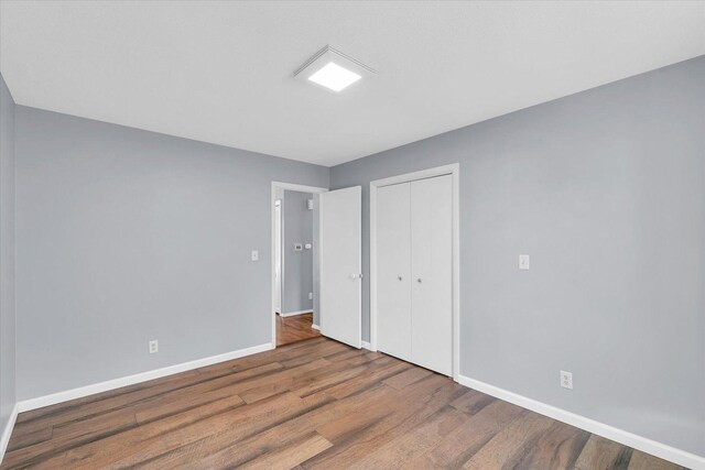 unfurnished bedroom featuring hardwood / wood-style flooring and a closet