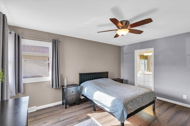 bedroom featuring ensuite bathroom, dark wood-type flooring, sink, and ceiling fan