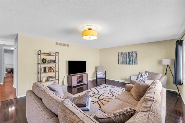 living room featuring dark hardwood / wood-style flooring and a textured ceiling