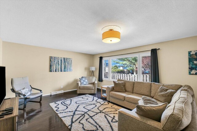 living room featuring a textured ceiling and dark hardwood / wood-style flooring