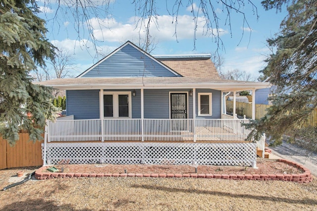 farmhouse featuring covered porch and a front lawn