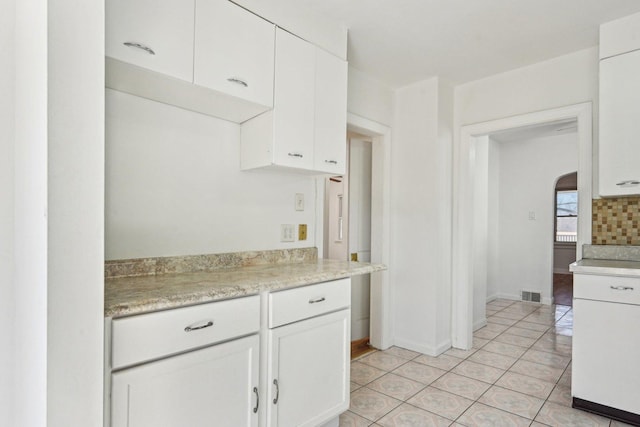 939 N Grace St, Lombard, IL 60148 - kitchen with white cabinetry, light tile patterned floors, and backsplash