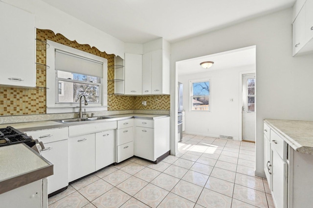 939 N Grace St, Lombard, IL 60148 - kitchen with sink, range with gas cooktop, tasteful backsplash, light tile patterned floors, and white cabinets