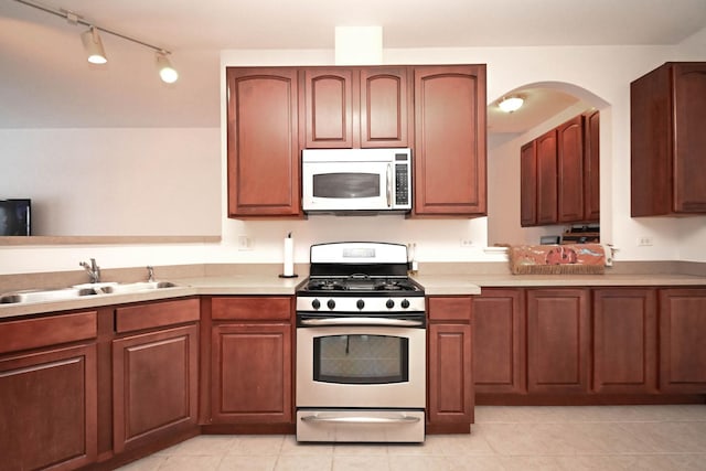 kitchen featuring sink, light tile patterned floors, and appliances with stainless steel finishes