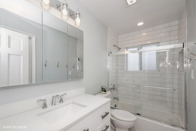 full bathroom featuring enclosed tub / shower combo, vanity, and toilet