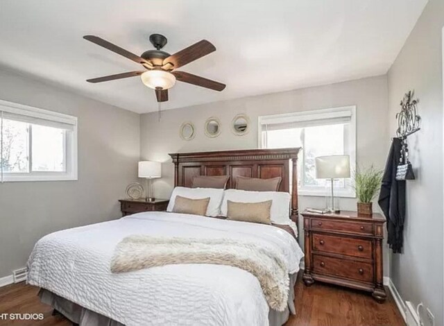 bedroom with dark hardwood / wood-style flooring and ceiling fan