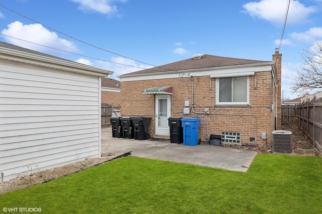 back of house with a lawn, central air condition unit, and a patio area