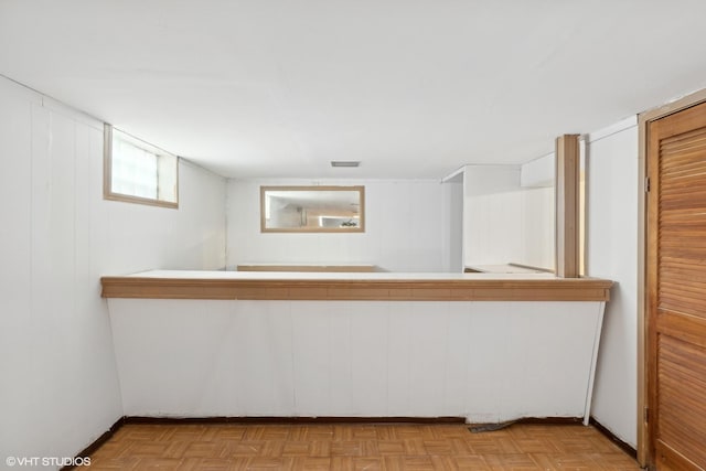 bar with white cabinetry and light parquet floors