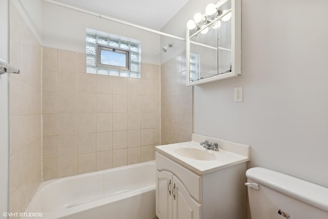 full bathroom with vanity, tiled shower / bath combo, and toilet