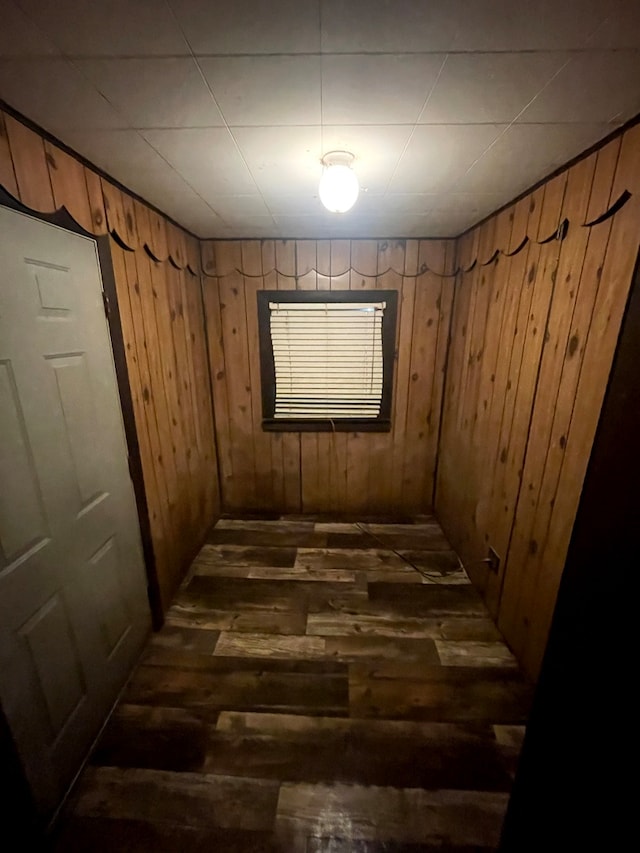 spare room with dark hardwood / wood-style flooring and wooden walls