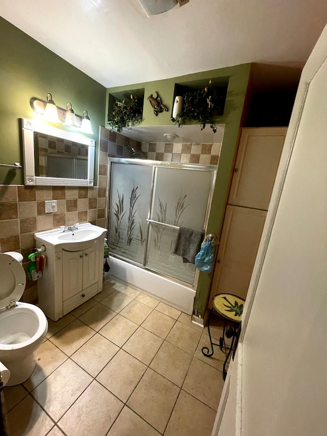 full bathroom with tile walls, enclosed tub / shower combo, vanity, toilet, and tile patterned floors