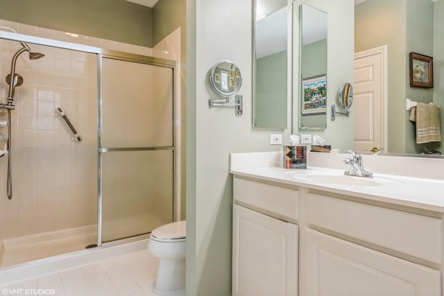 bathroom featuring vanity, toilet, a shower with shower door, and tile patterned flooring