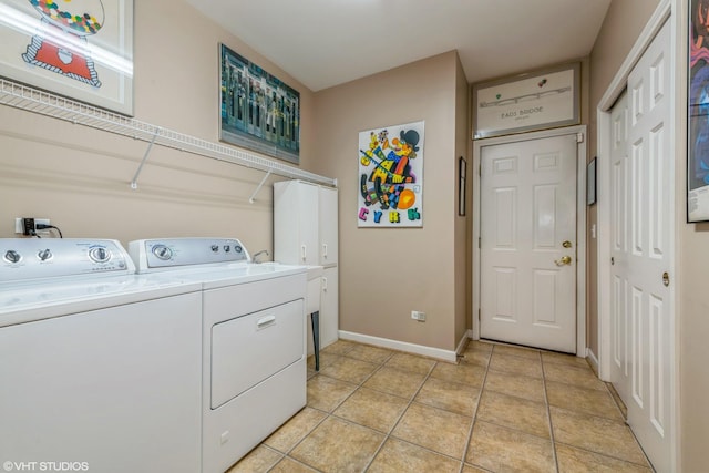 laundry room with cabinets, washer and clothes dryer, and light tile patterned floors