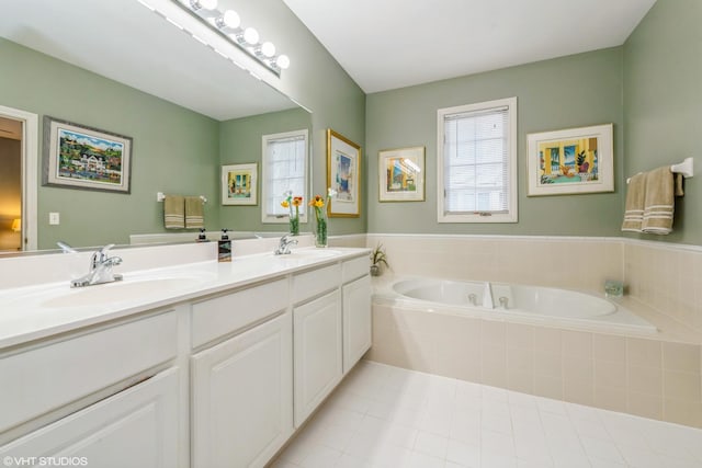 bathroom with tiled tub, vanity, plenty of natural light, and tile patterned flooring