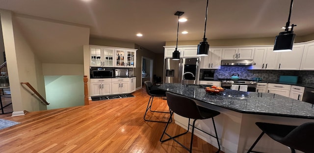 kitchen featuring stainless steel appliances, decorative light fixtures, and white cabinets